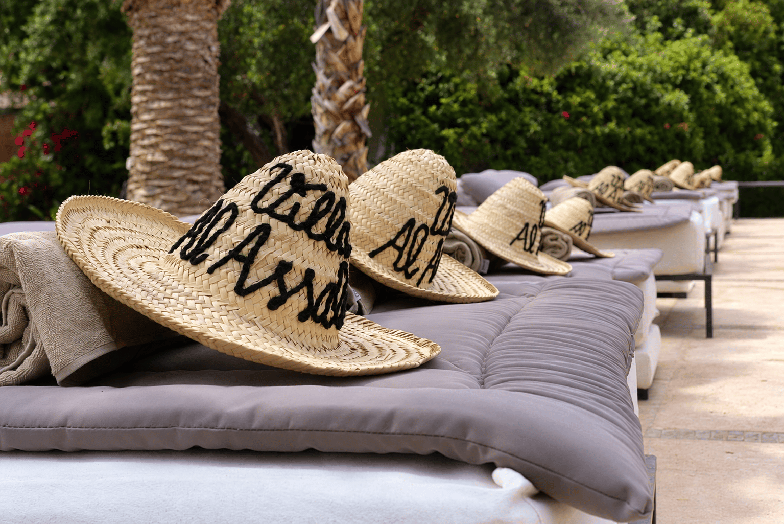 Transats au bord de la piscine, chapeaux Villa Al Assala